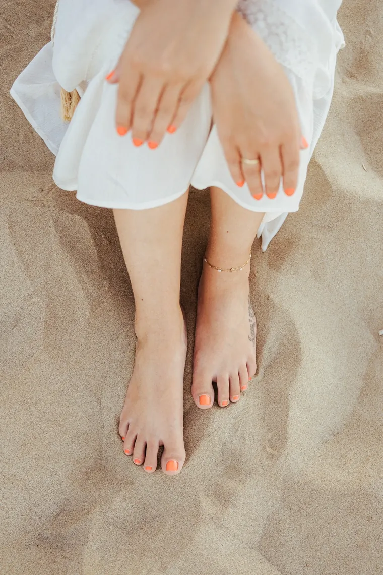 Gepflegte Hände und Füße im Sand